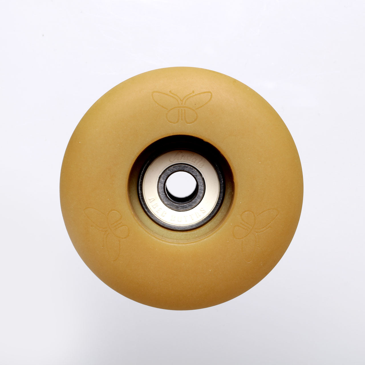 Photo: A beeswax-colored skateboard wheel on a white background made with Checkerspot's Pollinator™ Series Cast Polyurethane System in Natural Color. There are embossed butterflies on it with a white and steel wheel bearing in the center. 