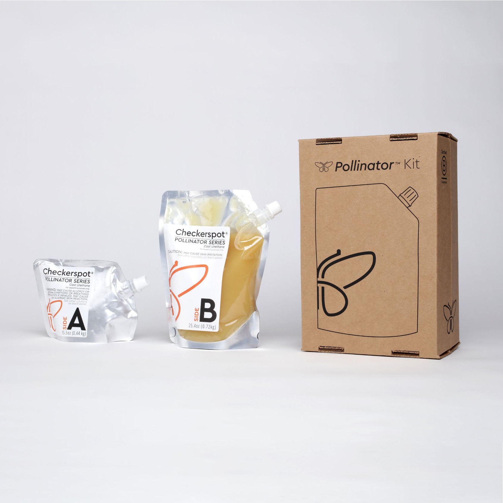 Photo: Two pouches and a box on a white background. To the right is a brown cardboard box with "Pollinator™ Kit" printed on it in black and a line drawing of a flexible pouch and a butterfly logo on it in black. On the box spine it says "Certified B Corporation". In the center is a clear and aluminum flexible pouch with a white spout. It has a label that says "Side B" with a beeswax-colored liquid material inside. On the left is a small aluminum spouted pouch that says "Side A".